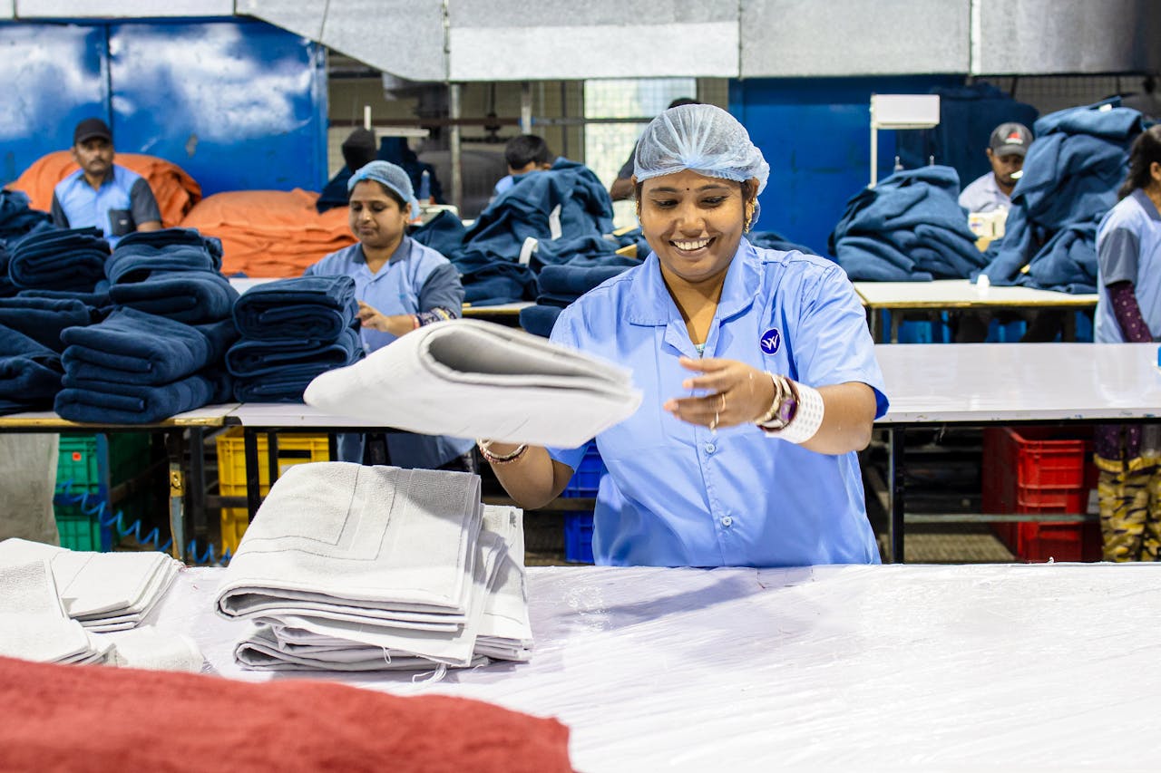 Textile factory workers folding fabric, showcasing teamwork and efficiency.